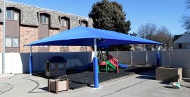 Image of a shade structure over a playground area.