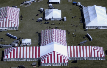 Image of 86 X red and white tent in shape of a T with other tents set for Cattlemens Ball