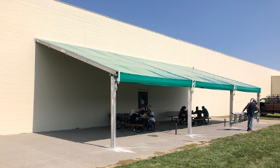 Image of a shade strucutre over a break area tables.
