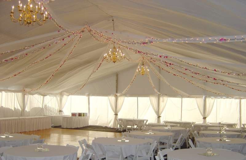 Clear span structure for wedding with white liner and brass chandeliers