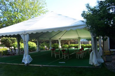 Image of tent set up on decking layed over empty pool