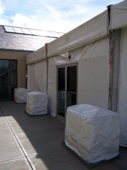 view of tent with covered weights by double doors